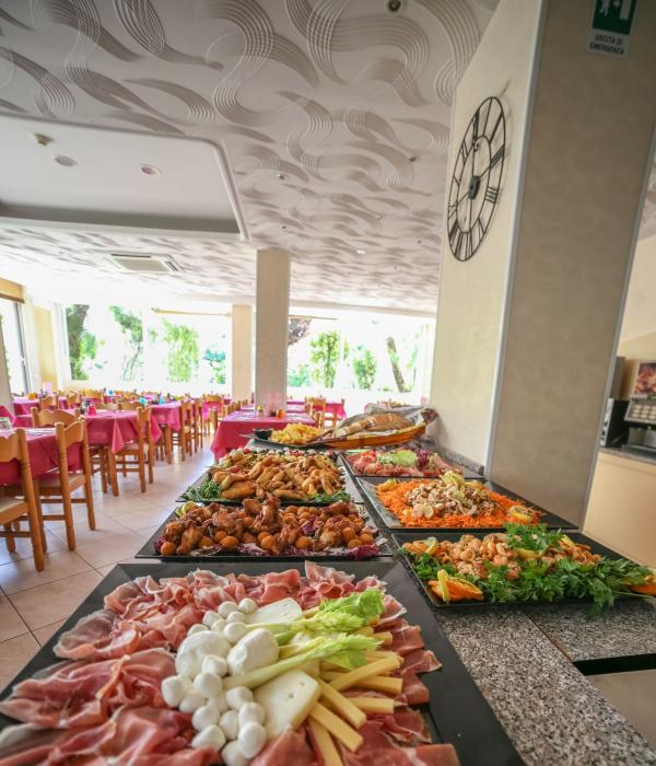 Buffet con affettati, formaggi e piatti caldi in un ristorante accogliente.