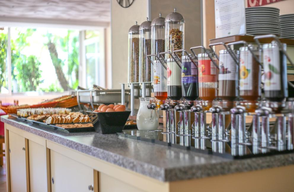 Buffet colazione con cereali, succhi e pane assortito.