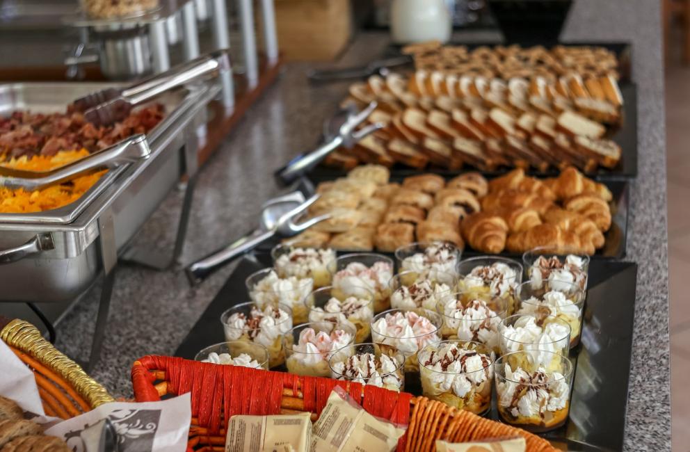 Buffet per colazione con cereali, pane, dolci e creme.